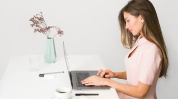 woman-in-pink-dress-using-laptop-computer-1586973